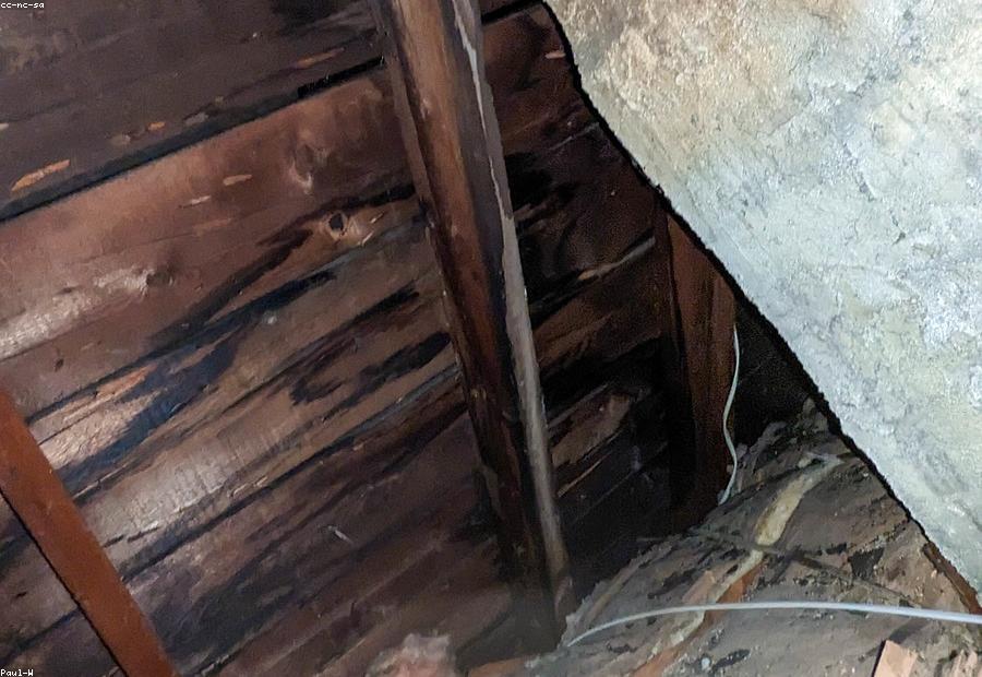 Inspector checking junction boxes and wiring condition in an older home's attic