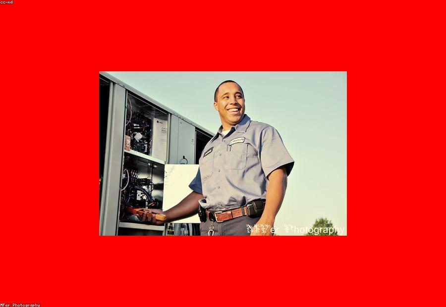 Technician performing a refrigerant pressure check during a spring AC tune-up