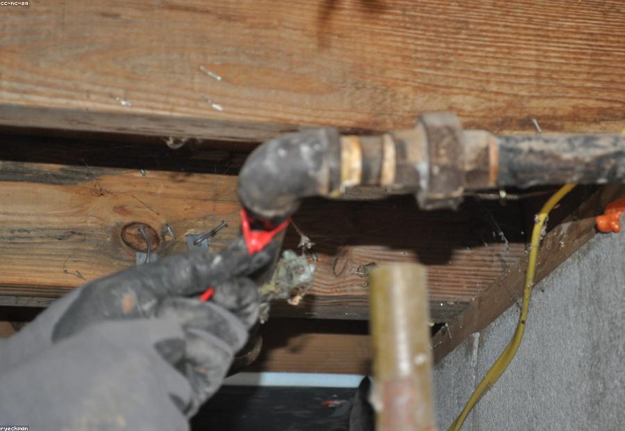 Technician using acoustic listening equipment to pinpoint a slab leak in a Dallas home