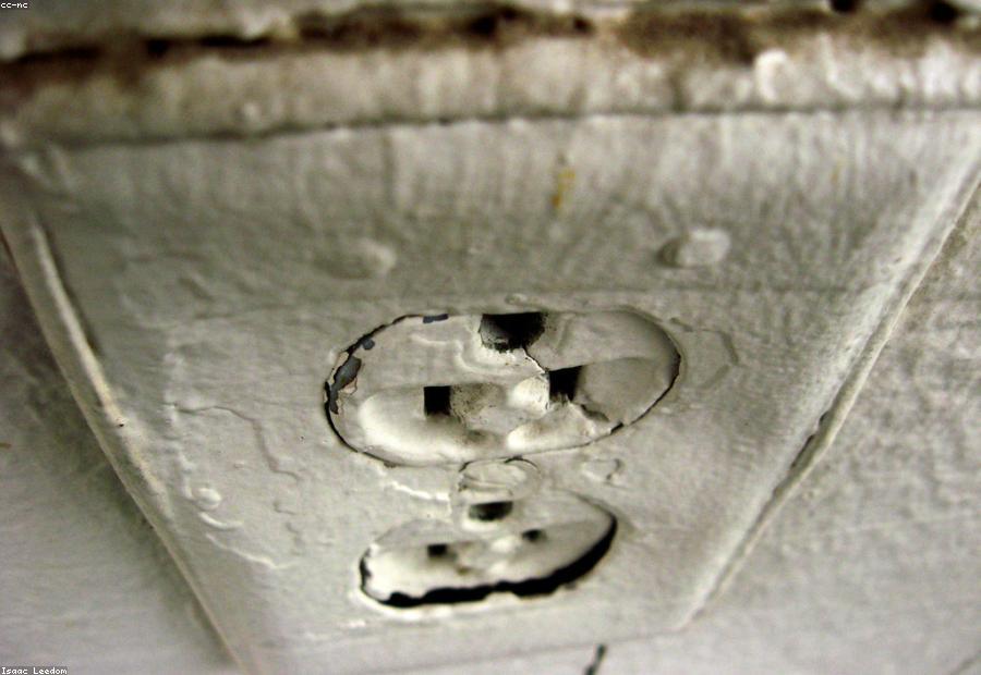 Ungrounded two-prong outlet on cloth-insulated wiring — a signature of pre-1960 construction